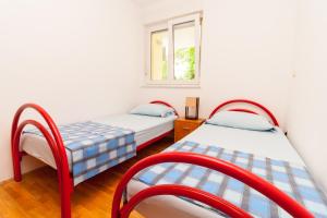 two beds in a room with a window at • Lungomare Beach Apartment Pula • in Pula