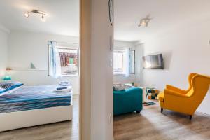 sypialnia z łóżkiem i żółtym krzesłem w obiekcie Apartments MB w mieście Kaštela
