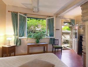 1 dormitorio con cama, escritorio y ventana en Les Rouges Gorges, en Giverny