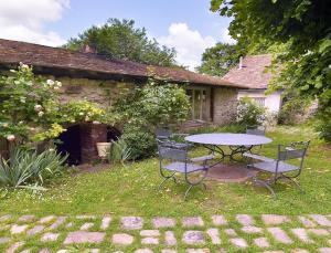 a table and chairs in the yard of a house at Les Rouges Gorges in Giverny