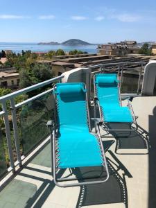 two blue chairs sitting on top of a balcony at Aussie Dream House in Formia