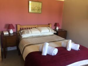 a bedroom with two beds with towels on them at Moorings in Fairbourne