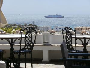 two chairs sitting at a table in front of the ocean at Kionia Galini Bangalows in Kionia