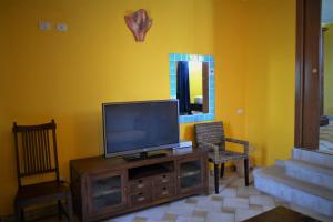 - un salon avec une télévision à écran plat dans un centre de divertissement en bois dans l'établissement Hotel dell'Ancora, à Villasimius