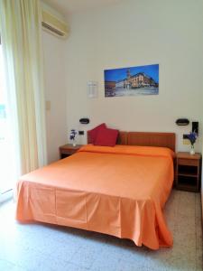 1 dormitorio con 1 cama con colcha de color naranja en Hotel Lariana, en Rímini