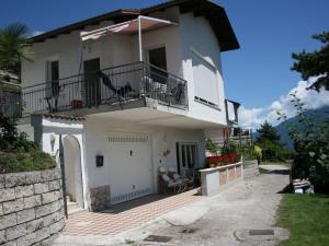 a white house with a balcony and a patio at Apartment Imma in Tremosine Sul Garda