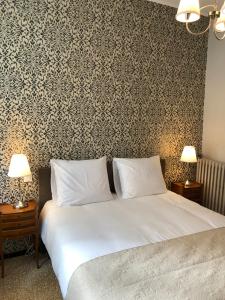- une chambre avec un lit et un mur recouvert de papier peint dans l'établissement Apartment Jeanne, à Carcassonne