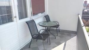dwa krzesła i stół na balkonie w obiekcie Apartmani Borko w Zagrzebiu
