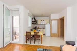 a kitchen and dining room with a table and chairs at Breki Apartman in Podstrana +17 photos