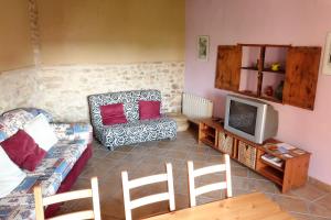 a living room with a couch and a tv at Casa Celestino in Alquézar