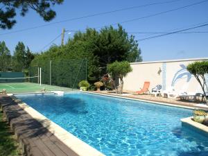 ピオランにあるCozy Holiday Home in Piolenc with Private Poolのテニスコート付きのスイミングプールが隣接しています。