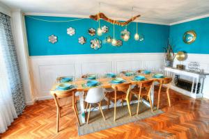 パラモスにあるFamily Home Palamosの青い壁のダイニングルーム(木製のテーブルと椅子付)