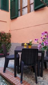 CivezzaにあるCa delle Rondiniの花の咲く建物の隣にある黒いテーブルと椅子