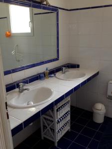een badkamer met 2 wastafels en een spiegel bij Mini Villa à 100m de la mer avec prise de recharge élec privative in Sari Solenzara