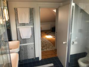 a bathroom with a shower and a toilet and a hallway at Camden Town House in London