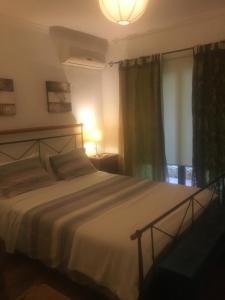 een slaapkamer met een bed, een lamp en een raam bij Quinta da Sao Joao - Villa Oliveira in Olhão