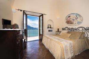 una camera da letto con un letto e vista sull'oceano di Villa Alba d'Oro - Historic luxury villa ad Amalfi