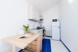 Una cocina con una mesa de madera y un refrigerador. en Residence Gioia, en Furore 33 fotos más