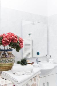 baño con lavabo y jarrón con flores en Residence Gioia, en Furore