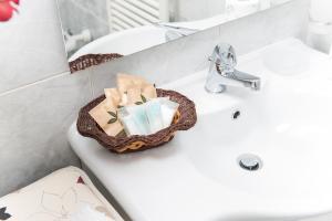 - un lavabo dans la salle de bains avec une corbeille d'articles de toilette dans l'établissement Residence Gioia, à Furore