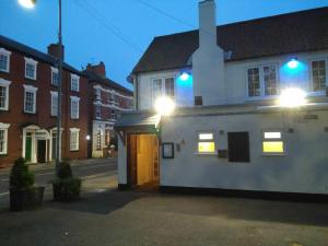 a white house with blue lights on a street at The Tiger - formerly Cassia Rooms in Worksop