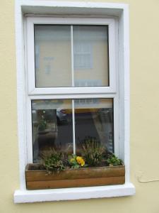 una ventana con flores en una caja de la ventana en Inglenook en Kinsale