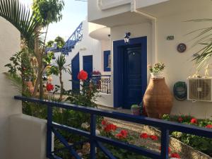 una porta blu su una casa con fiori di Psaras Apartments a Stalida