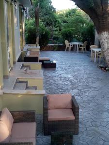 a row of chairs and tables on a patio at Melina Apartment in Loutrópolis Thermís