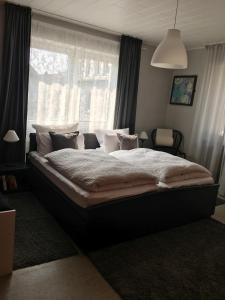a large bed in a bedroom with a window at Gasthof zur alten Feuerwache in Bad Hönningen