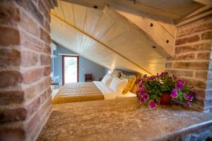 a bedroom with a bed and a brick wall at Medin Apartments BluVista in Petrovac na Moru