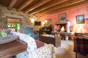 Una sala de estar con un sofá y una chimenea. en Casa Rural Graña da Acea, en Monfero