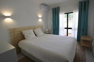 um quarto com uma cama grande e uma janela em Vale Caranguejo em Tavira