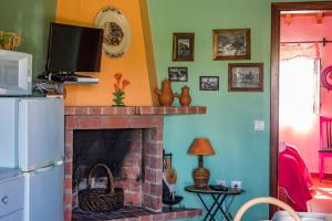 sala de estar con chimenea y TV en la pared en Monte do Costa en Aljezur