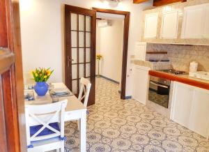 a kitchen with a white table and a table and chairs at Il Grazioso Giardinaccio in Palermo