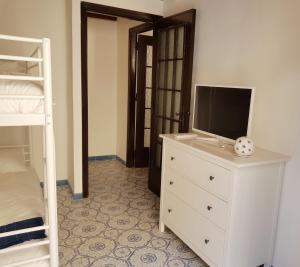 - une chambre avec une télévision sur une commode et des lits superposés dans l'établissement Il Grazioso Giardinaccio, à Palerme
