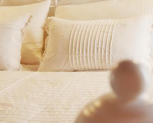 - un lit avec des draps et des oreillers blancs dans l'établissement Il Grazioso Giardinaccio, à Palerme