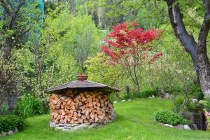 un tas de bois de feu dans un jardin dans l'établissement Appartamenti nonna Carmen, à Sappada 10 autres photos