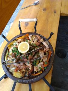 a pan filled with shrimp and a lemon on a table at Guest House Todorini kashti in Koprivshtitsa