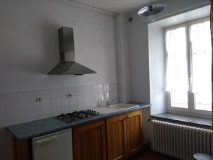 een keuken met een fornuis, een wastafel en een raam bij FERME DU HAUT BARBA chambres d'hôtes & gîte in Liézey