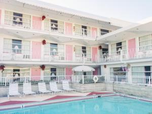 ワイルドウッドにあるPink Champagne Motelの建物の前にスイミングプールがあるホテル