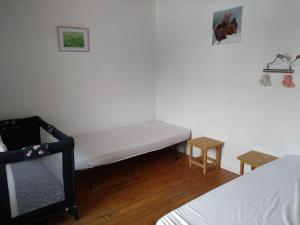 Cette petite chambre comprend un lit et deux tables. dans l'établissement FERME DU HAUT BARBA chambres d'hôtes & gîte, à Liézey