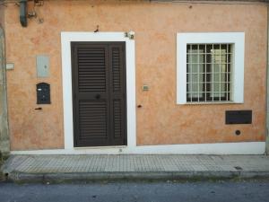 una porta marrone e una finestra su un edificio di Via Roma 12 a Messina