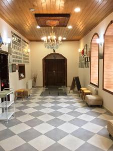 a lobby with a checkered floor and a wooden ceiling at Camlihemsin Tasmektep Hotel in Çamlıhemşin