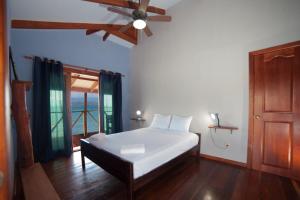 a bedroom with a bed and a ceiling fan at Aqui hoy cabañas in Bocas del Toro