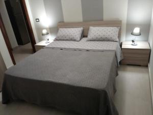 une chambre avec deux lits et deux tables de nuit dans l'établissement Roma 12, à Messina