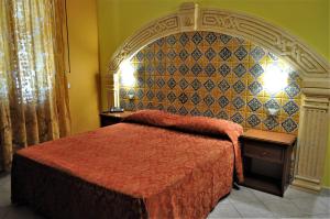 a bedroom with a bed with a red bedspread at Al-Tair in San Vito lo Capo