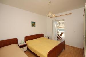 a bedroom with two beds and a view of a patio at Apartments Niko Metajna, island Pag in Metajna