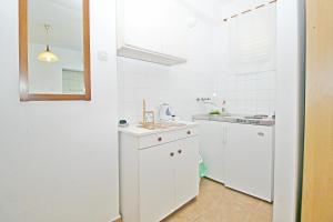 a white kitchen with a sink and a white refrigerator at Bed and breakfast Porto del Mar in Medulin +42 photos