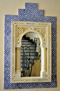 um espelho numa parede com azulejos azuis e brancos em Al-Tair em San Vito lo Capo