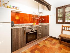 a kitchen with orange tiles on the wall at Chalecito en la Herradura- Casa Kwetu in La Herradura